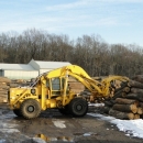 A Crane Picking Up Logs To Feed To The Mill